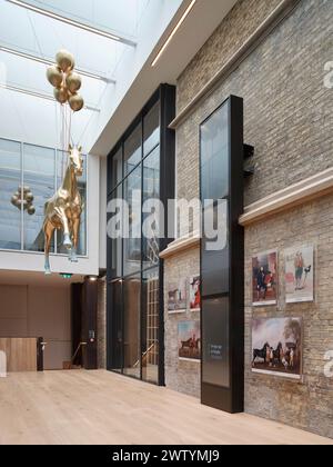 Foyer mit hängender Pferdeskulptur und Timeline. Brighton Dome Corn Exchange and Studio Theatre, Brighton, Großbritannien. Architekt: Feilden Clegg Stockfoto