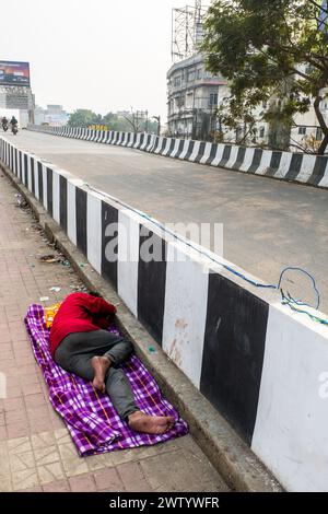 Obdachloser Indianer, der auf dem Bürgersteig in Guwahati, Assam, Indien schläft Stockfoto