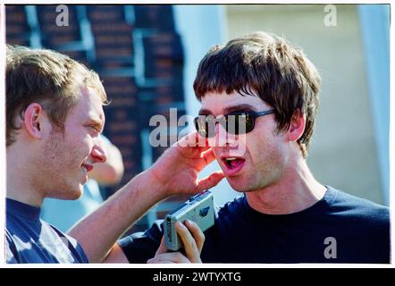 NOEL GALLAGHER, INTERVIEW MIT DICTAPHONE, BACKSTAGE, READING FESTIVAL, 2001: Noel Gallagher von Oasis wird am 25. August 2001 mit einem altmodischen DICTAPHONE-DICTAPHONE auf dem Reading Festival, Reading, England interviewt. Die Band war gerade mit ihrem vierten Studioalbum Standing on the Shoulder of Giants auf Tournee gegangen. Stockfoto