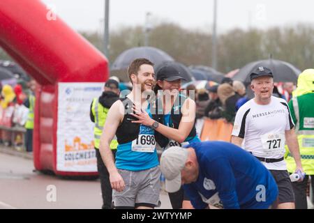 Läufer nach Abschluss des Halbmarathons in Colchester 2024. Der Lauf dient der Unterstützung des Robin Cancer Trust. Ein Paar feiert gemeinsam Stockfoto