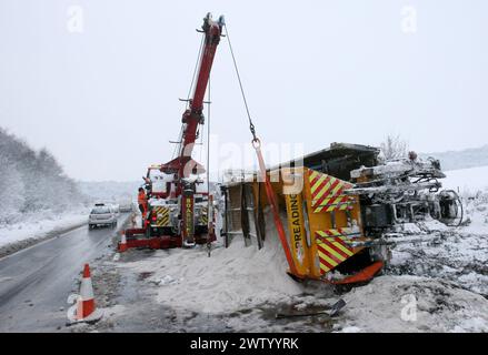 12/10 HEUTE FOTO ...wird Ein Streuwagen des Hampshire County Council mit einem Kran nach rechts gebracht, nachdem er abgestürzt und auf dem Eis auf der A3 in BU umgekippt wurde Stockfoto