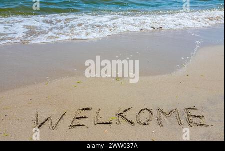 Handschreiber-Inschrift Welkome-Wort über tropischen Sandstrand, Reise-Konzeptkarte für Urlaub. Stockfoto