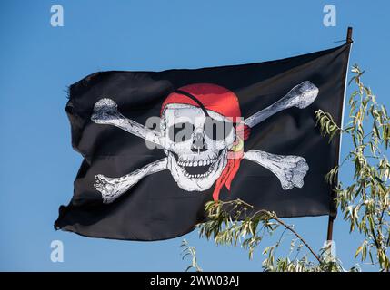 Ein Schädel mit Kreuz, Piratenflagge, die im Wind winkt. Stockfoto