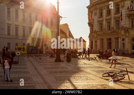 SIBIU, SIEBENBÜRGEN, RUMÄNIEN - 8. JULI 2020: Dämmerungslicht auf dem Großen Platz der Stadt, mit Touristen und einer Ballerina bei der Fotosession. Stockfoto