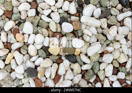 Bunte Kieselsteine in verschiedenen Größen schaffen eine natürliche strukturierte Oberfläche. Stockfoto
