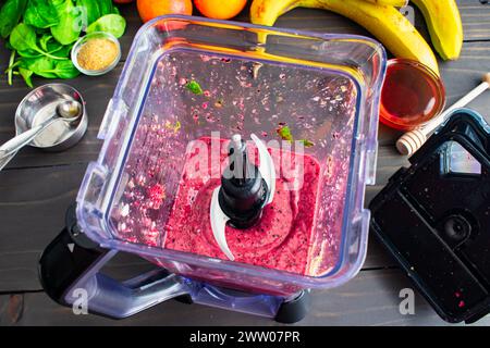 Overhead View of Blood Orange Smoothie Ingredients in a Mixer: Smoothy mit Blutorangen, gemischten Beeren, Bananen, Babyspinat und mehr Stockfoto