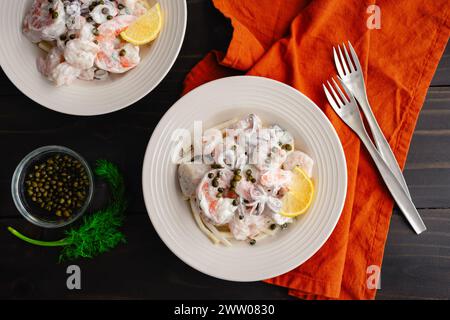 Poached Seafood Salat serviert auf Selleriewurzel Remoulade: Schüsseln mit Garnelen, Tintenfischen und Jakobsmuscheln mit Zitronendilsauce serviert über SellerieRemoulade Stockfoto