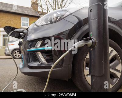 Elektroauto angeschlossen an eine Straßenladelampe für Elektrofahrzeuge, London, Großbritannien Stockfoto