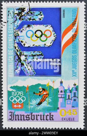 Gestempelte Briefmarke von Äquatorialguinea, die die Olympischen Winterspiele 1976, Innsbruck zeigt: Plakate früherer Spiele, um 1975. Stockfoto