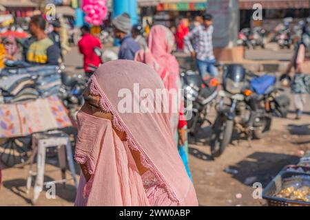 Jodhpur, Indien - 19. Dezember. 2023: Eine Frau mit rosa Kopftuch auf dem Straßenmarkt von Jodhpur in Rajasthan Stockfoto