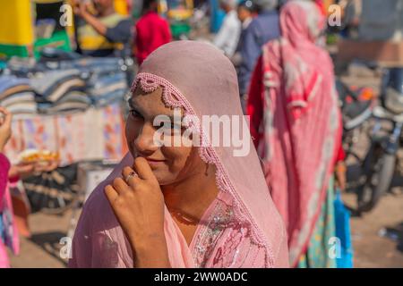 Jodhpur, Indien - 19. Dezember. 2023: Eine Frau mit rosa Kopftuch auf dem Straßenmarkt von Jodhpur in Rajasthan Stockfoto