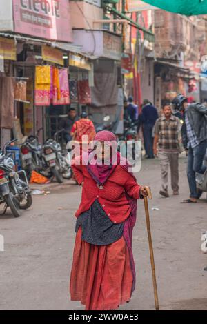 Jodhpur, Indien - 19. Dezember. 2023: Eine ältere Frau mit rotem Kleid auf dem Straßenmarkt von Jodhpur in Rajasthan Stockfoto