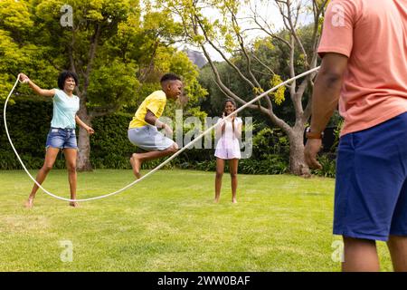 Eine afroamerikanische Familie genießt einen sonnigen Tag mit einem Sprungseil im Freien Stockfoto