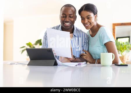 Ein junges afroamerikanisches Paar überprüft zu Hause die Finanzen Stockfoto