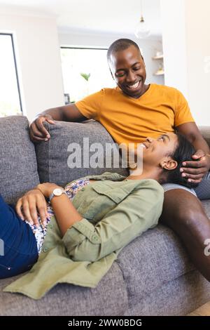 Ein vielseitiges Paar genießt einen entspannten Moment auf dem Sofa zu Hause Stockfoto