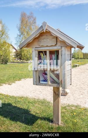 Kleines, hausgemachtes Holzhaus im Stadtpark, in dem die Bürger Bücher kostenlos mitnehmen oder hinterlassen können. Das zweite Leben der Bücher. Stockfoto