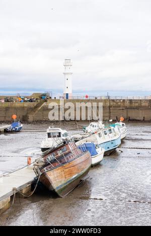 Newhaven, Schottland, Vereinigtes Königreich - März 2024: Der Leuchtturm am Hafen von Newhaven, der am Ende des Wellenbrechers steht, mit Metallzäunen an beiden Seiten. Stockfoto