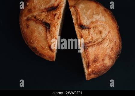 Zwei Hälften frisches Brot auf schwarzem Hintergrund. Hochwertige Fotos Stockfoto