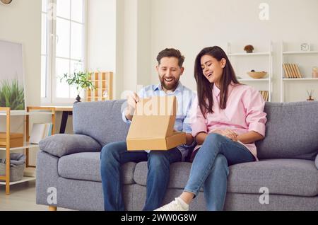 Männliche und weibliche Kunden zu Hause sehen sich den Inhalt der Verpackung aus der Online-Shop-Bestellung an. Stockfoto