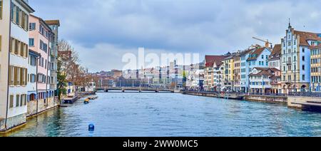 ZÜRICH, SCHWEIZ - 3. APRIL 2022: Das malerische Stadtbild des alten Zürcher Stadtzentrums umfasst historische Häuser am Ufer der Limmat, Crea Stockfoto