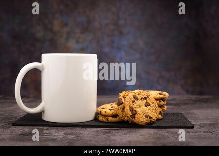 Vanille-Schokoladen-Chips-Kekse neben einem weißen Becher. Modell. Stockfoto