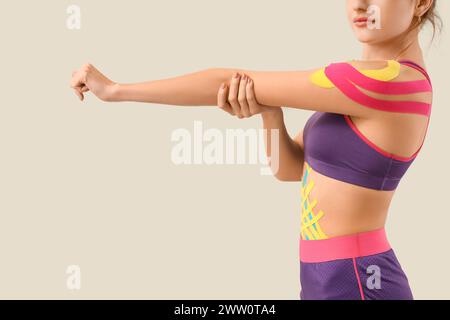 Junge Frau mit Physioband auf hellem Hintergrund Stockfoto