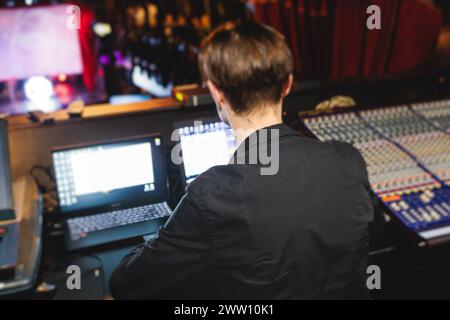 Ansicht des Bedieners des Lichttechnikers, der während eines Live-Event-Konzerts auf der Bühne am Arbeitsplatz des Mischpults arbeitet, Show-Übertragung, Lichtmischer-Controller-Pan Stockfoto