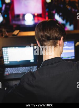 Ansicht des Bedieners des Lichttechnikers, der während eines Live-Event-Konzerts auf der Bühne am Arbeitsplatz des Mischpults arbeitet, Show-Übertragung, Lichtmischer-Controller-Pan Stockfoto