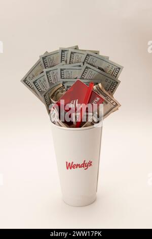 Maplewood, Minnesota. Wendy's Fastfood-Kette. Wendys Limonade-Becher gefüllt mit Geld, Visakarte und einem Strohhalm auf weißem Hintergrund. Stockfoto