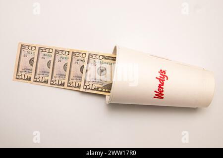 Maplewood, Minnesota. Wendy's Fastfood-Kette. Wendys Limonade-Becher mit Geld, das aus dem Becher auf weißem Hintergrund fließt. Stockfoto