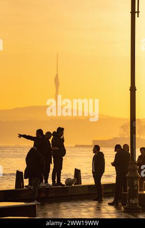 Istanbuliten gehen ihrem täglichen Leben in der Stadt nach und zeigen auf die Umgebung mit dem Camlica-Turm in der Ferne Stockfoto