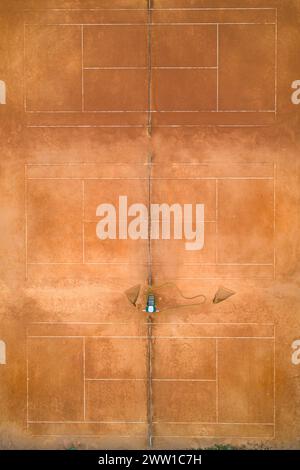 Die Drohne aus der Luft wurde oben unten auf einem leeren Tennisplatz mit Lehm-Spielplatz gedreht Stockfoto