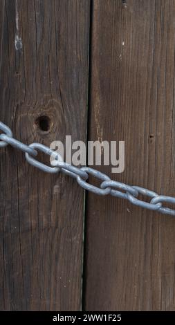Stabile Metallkette, strukturierter Holzhintergrund, Vintage-Feeling, starker Kontrast Stockfoto