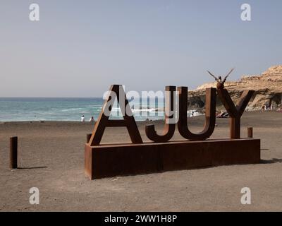 Strandschild und Strandszene im Dorf Ajuy auf dem schwarzen vulkanischen Sand, Playa de Ajuí, Ajuy, Pajara, Westküste von Fuerteventura, Kanarische Inseln, Spanien Stockfoto