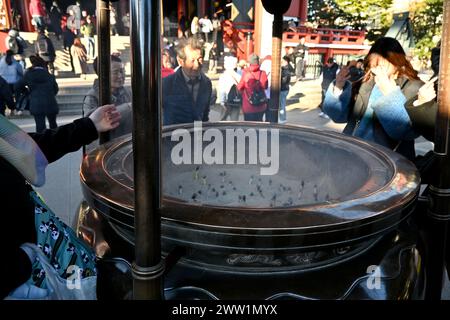 Die Menschen versammelten sich um Räucherbrenner in einem Jokoro im Sensō-JI-Tempel – Asakusa, Taito-Stadt, Tokio, Japan – am 28. Februar 2024 Stockfoto