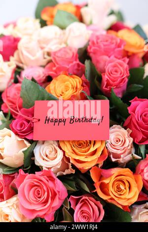 Blumenstrauß mit schönen Rosen mit Happy Birthday Karte, Nahaufnahme Stockfoto