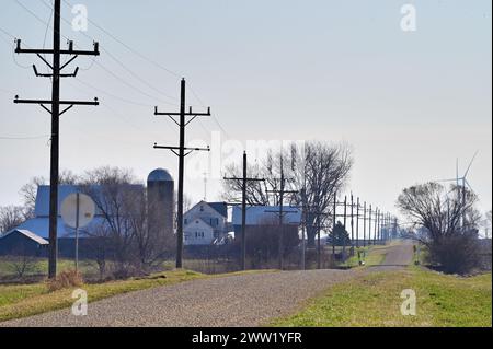 Steward, Illinois, USA. An einem sonnendurchfluteten Spätwintertag im ländlichen Illinois erstreckt sich eine Landstraße mit Schotter bis zum Horizont. Stockfoto