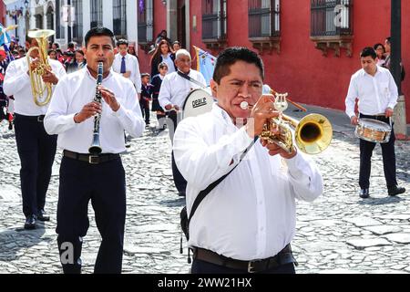 Antigua, Guatemala. März 2024. Eine Marschkapelle leitet die Semana Santa Festival Queen, umgeben von Schulkindern, während sie in Vorbereitung auf die Holly Week am 20. März 2024 in Antigua, Guatemala, durch das historische Zentrum zieht. Die opulenten Prozessionen, detailgetreuen Alfombras und jahrhundertealten Traditionen ziehen mehr als 1 Million Menschen in die alte Hauptstadt. Quelle: Richard Ellis/Richard Ellis/Alamy Live News Stockfoto