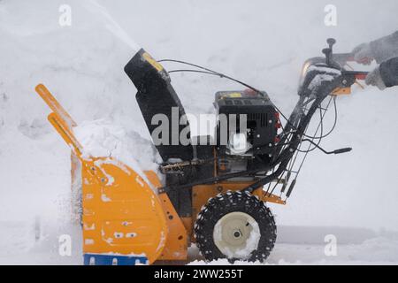 Schneefräse in Aktion. Es ist schwer, in dieser Nahaufnahme Schnee von der Einfahrt zu entfernen. Was für eine leistungsstarke und effiziente Abbaumaschine Stockfoto