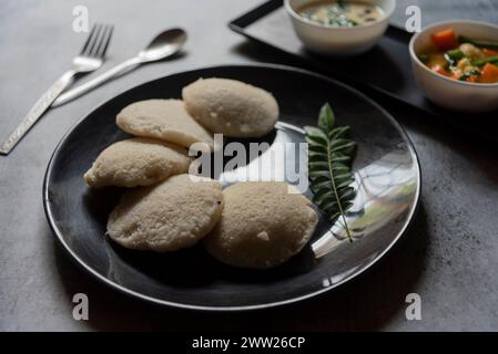 Südindische Snacks idli Sambar oder idly Sambhar, zubereitet durch Dämpfen fermentierten Reis und serviert mit Kokos-Dip und Gemüsesuppe oder Sambar. Stockfoto