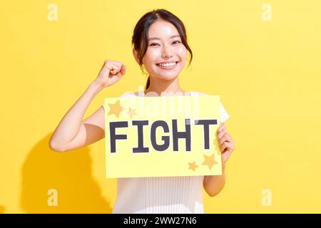 Eine Frau, die ein Schild mit der Aufschrift Kampf hochhält Stockfoto