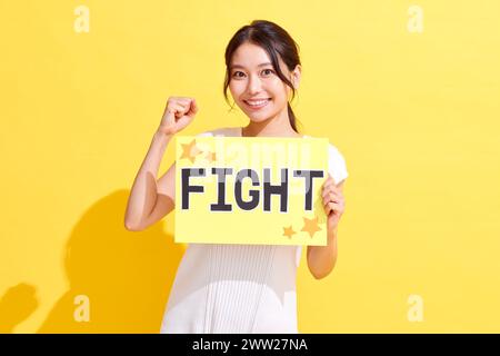 Eine Frau, die ein Schild mit der Aufschrift Kampf hochhält Stockfoto