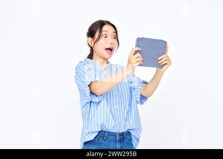 Eine Frau, die eine Tafel hält und überrascht aussieht Stockfoto