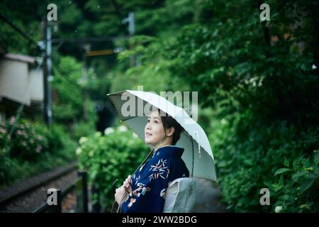 Eine Frau in einem Kimono, die einen Weg entlang geht Stockfoto