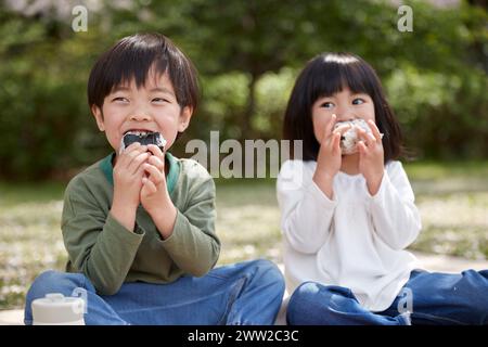 Zwei Kinder sitzen auf dem Boden und essen Stockfoto