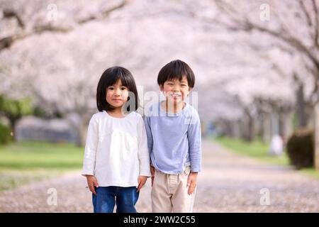 Zwei kleine Kinder stehen vor einem Baum Stockfoto