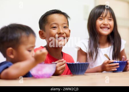Kinder essen rasiertes Eis Stockfoto