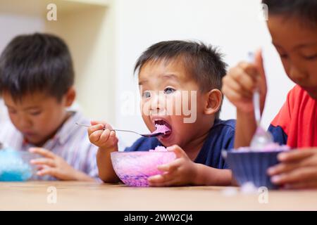 Kinder essen rasiertes Eis Stockfoto
