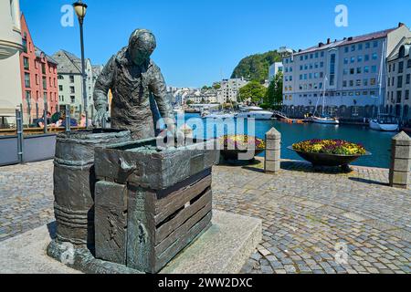 Alesund, Norwegen - 06 07 2022: Schöner Hafen des Alesund-Kanals und Statue der Heringsfrau Sildekona, mit farbenfroher Jugendstilarchitektur im Hintergrund Stockfoto