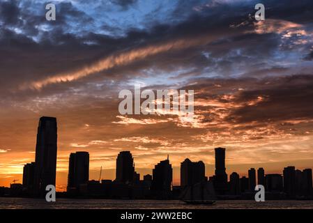 Dramatischer Sonnenuntergang über den Silhouetten der Skyline von Jersey City – New York, USA Stockfoto